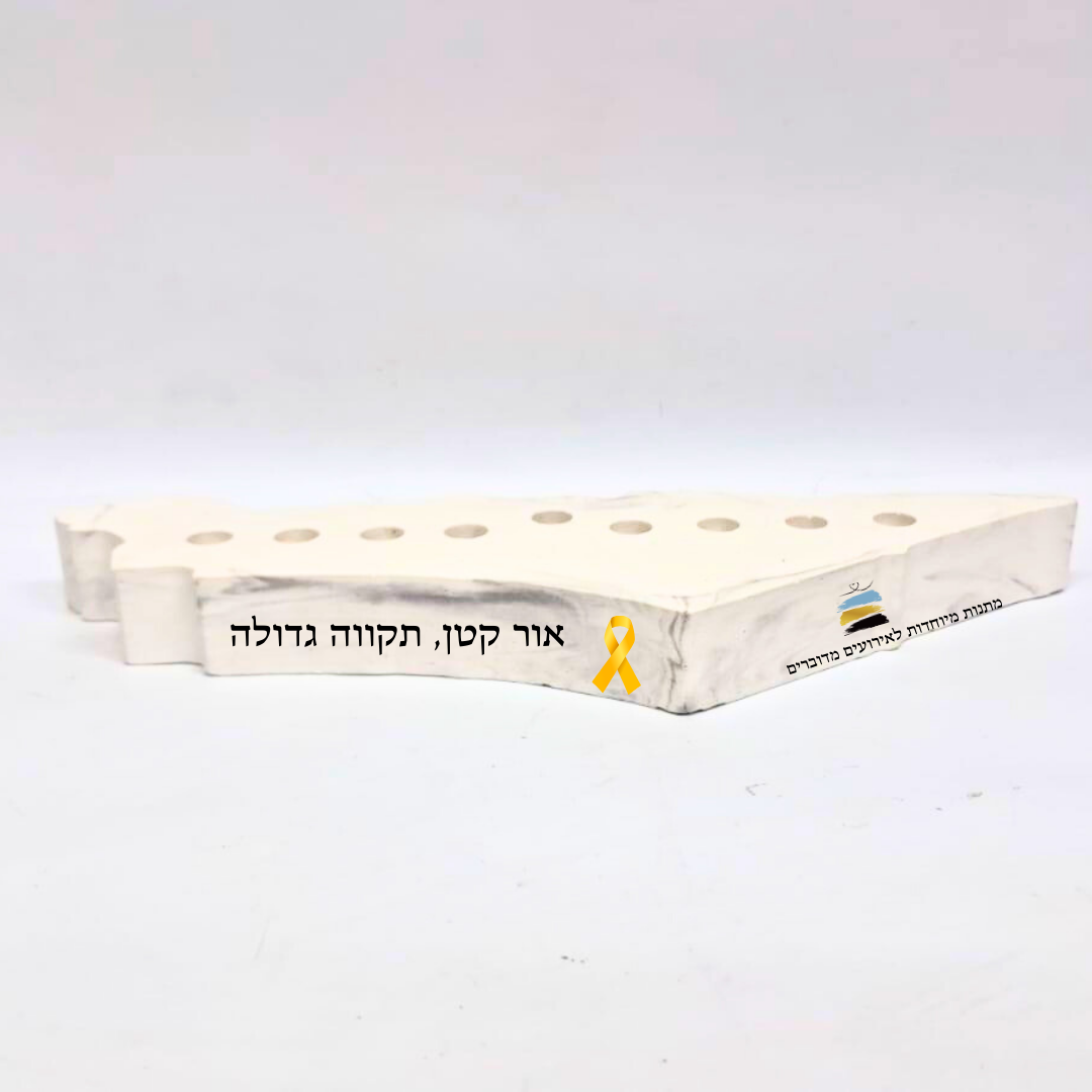 חנוכייה לבנה עם כיתוב אור קטן תקווה גדולה וסרט צהוב לתמיכה בחטופים