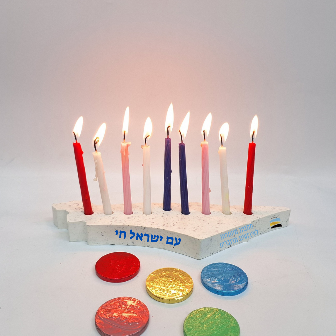 חנוכייה עם 9 נרות דולקים ועליה הכיתוב עם ישראל חי, לצידה גלי שוקולד