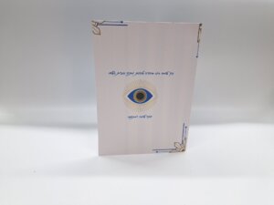 ספר בעיצוב אלגנטי עם עין כחולה וזהב וטקסט בעברית על השער